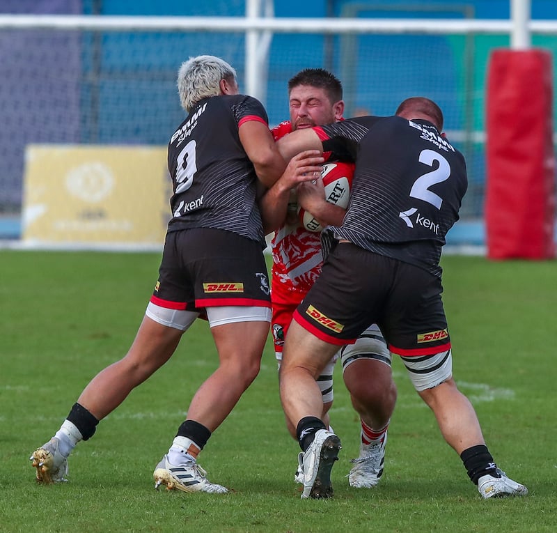 Rory Smith of Dubai Tigers gets tackled by Bahrain players.