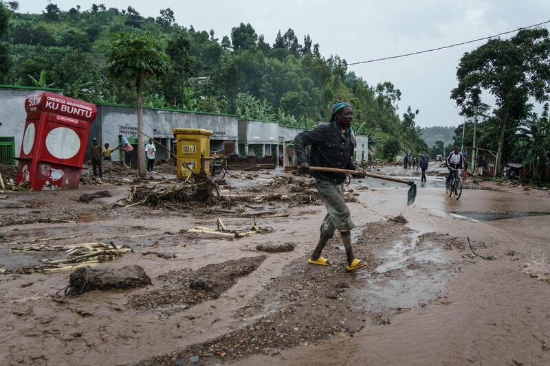 A man removes debris from a road in Rwanda on the border with the Democratic Republic of the Congo, where the official death toll from flooding has reached 176, with others still missing. AFP