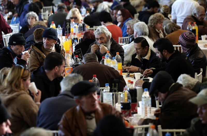 People in need and the homeless receive their annual Christmas meal provided by the City of Athens in an indoor stadium in Athens, Greece.  EPA/SIMELA PANTZARTZI
