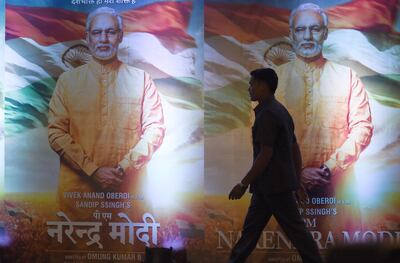 (FILES) In this file photo taken on January 07, 2019, an Indian man walks in front of posters of the upcoming Bollywood film "PM Narendra Modi" - a biopic on Indian Prime Minister Narendra Modi, during an event to launch the poster of the film in Mumbai. A biopic about Prime Minister Narendra Modi described by his opponents as propaganda has been barred from release during the national election, a government body overseeing the poll said on April 10. / AFP / Indranil MUKHERJEE
