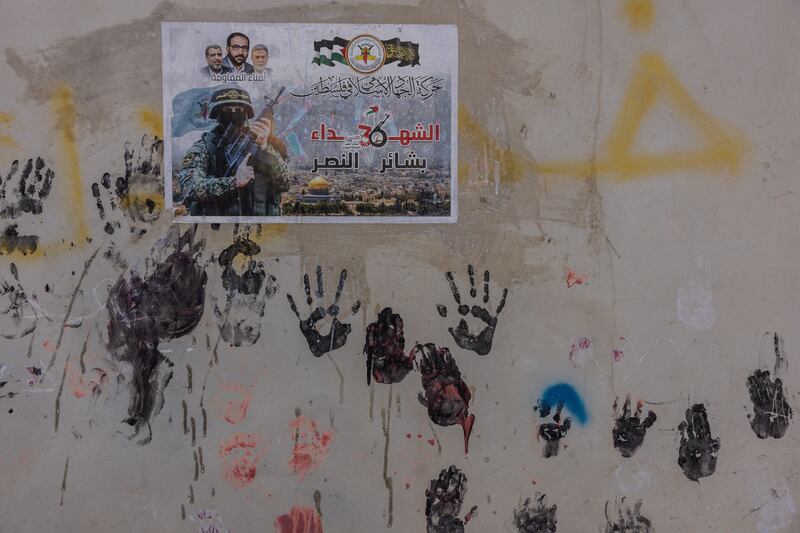 Paintings of children's hands and a poster of a resistance fighter in Jenin refugee camp in the northern part of the occupied West Bank 