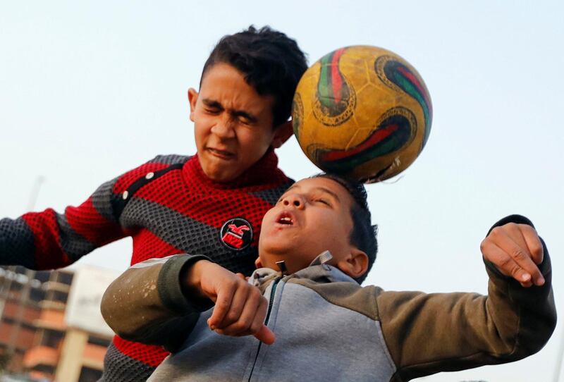 Children play football on a dusty field in Cairo, Egypt. Reuters