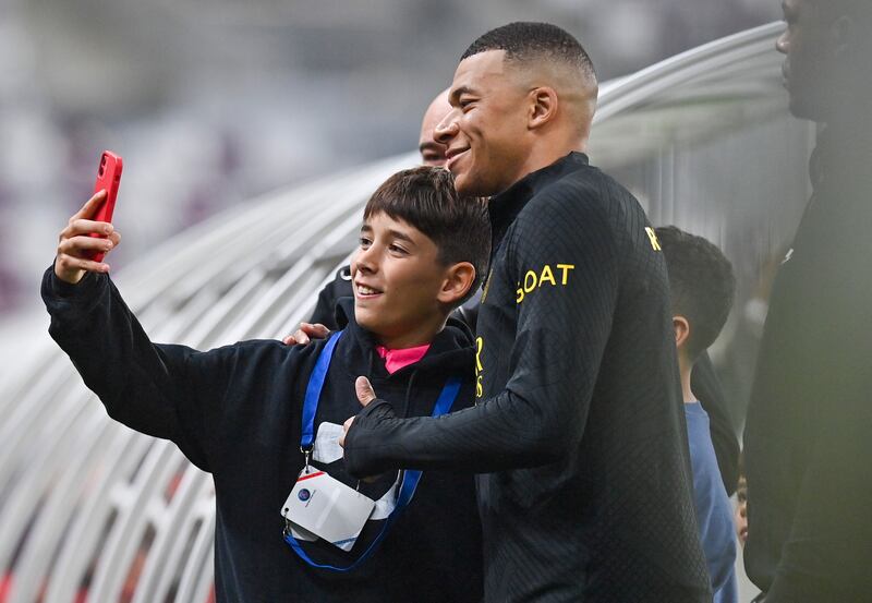 Kylian Mbappe takes a selfie with a fan at the end of PSG's training session at Khalifa International Stadium in Doha. PSG will face a Riyadh All-Star XI team, which will include Cristiano Ronaldo, on Thursday. EPA