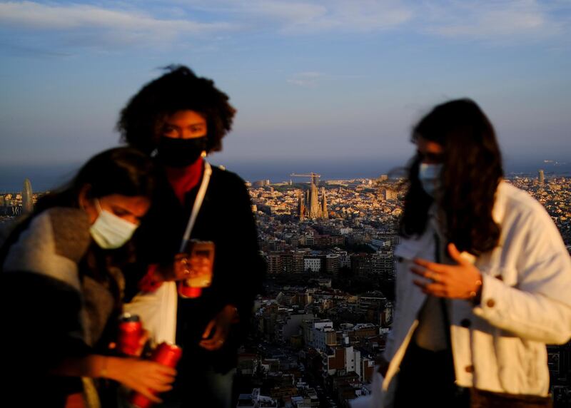 Women wearing protective face masks at a lookout point, with a view of the Sagrada Familia basilica in the background, in Barcelona, Spain. Reuters