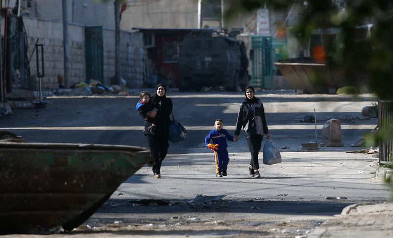A Palestinian mother and her children walk out of the Jenin camp as a raid on the refugee camp enters a third consecutive day. EPA