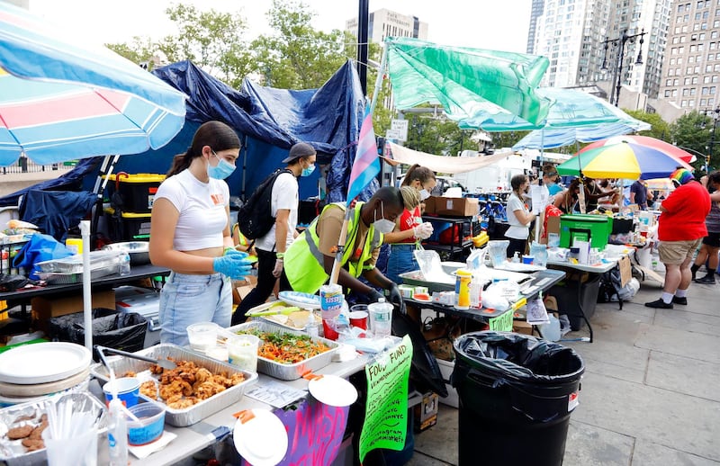 Volunteers serve food to people in a park that has become the site of an Occupy City Hall protest. EPA