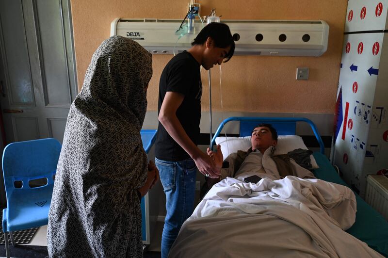 Relatives visit an injured pupil in hospital. The school targeted was reported to be the Abdul Rahim Shaheed High School. AFP