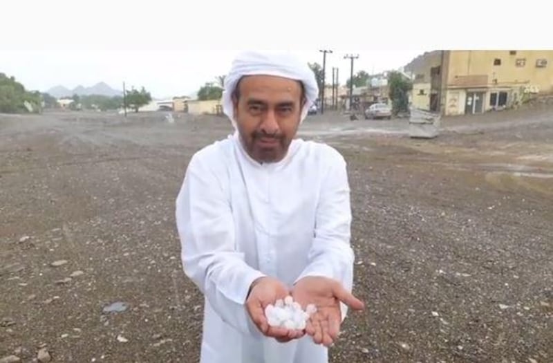 A man wearing national dress holds a pile of hail stones on the Masafi to Dibba road, according to the Storm Centre Twitter account. Courtesy: Storm Centre