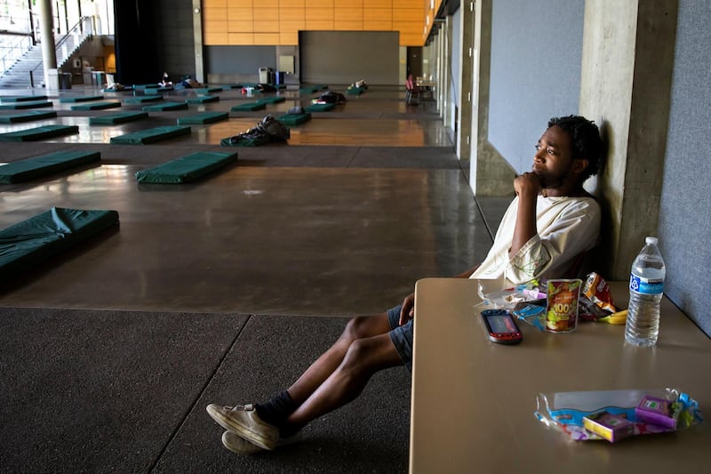Carlitos, 24, came to the cooling center at Fisher Pavilion in the Seattle Center Saturday night after experiencing symptoms of heat exhaustion during a record-breaking heat wave Sunday June 27, 2021. The shelter is open 24/7 until Tuesday morning and only a few of the 73 beds are occupied as of Sunday morning. Dinner, snacks and other services are provided. (Bettina Hansen/The Seattle Times via AP)