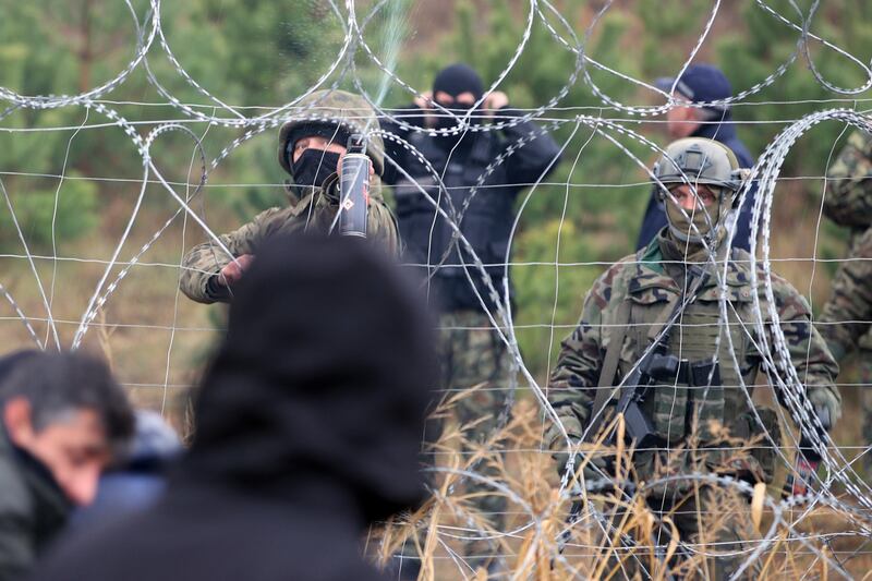Polish border guards stand near the barbed wire at the border. AP