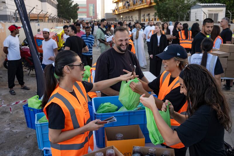 Smiles all round as volunteers hand out meals in Al Quoz Industrial 1. Antonie Robertson / The National