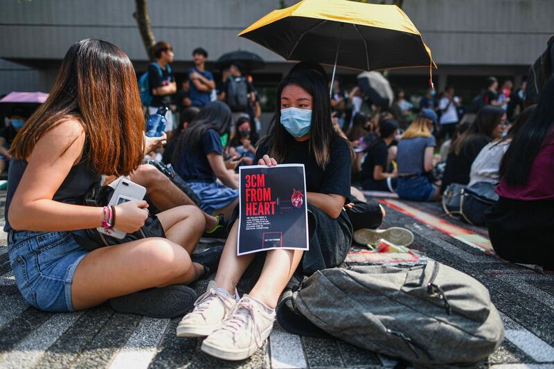 A student displays a poster referring to the recent police shooting of an 18-year-old student on October 1. AFP