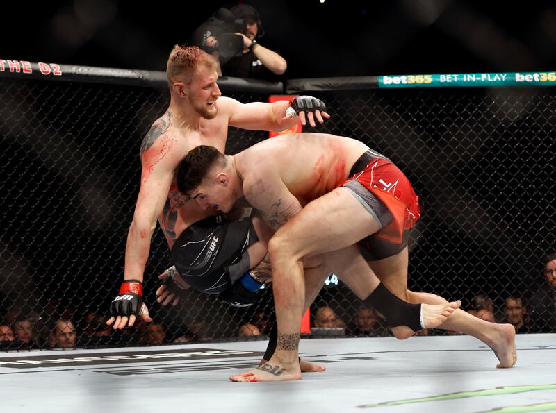 Tom Aspinall takes Alexander Volkov to the ground during their main event heavyweight bout at UFC London. Reuters
