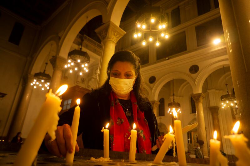 An Egyptian worshipper lights candles during Christmas Eve Mass at Saint Joseph Catholic Church in Cairo. AP