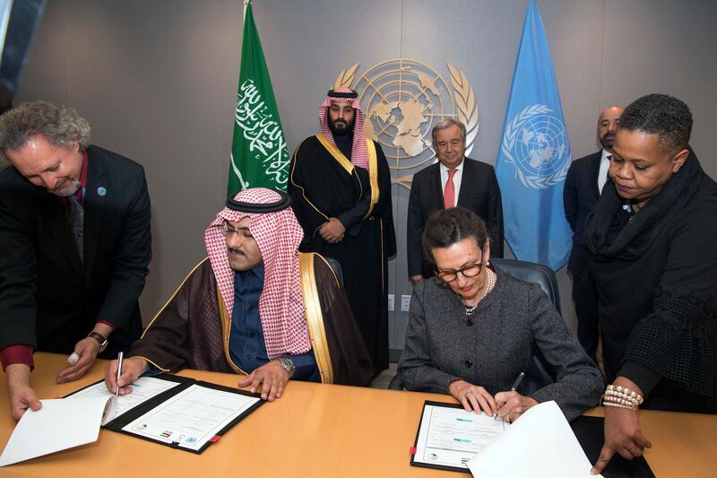 UN Secretary-General Antonio Guterres, right rear, and Saudi Arabia's Crown Prince Mohammed bin Salman, left rear, watch as their representatives sign a voluntary financial contribution memo for the Yemeni humanitarian response plan, on Tuesday, March 27, 2018, at the UN headquarters. Eskinder Debebe / United Nations via AP