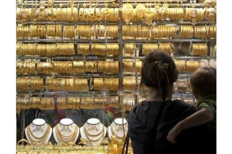 Window shoppers peruse a display of gold jewellery outside a store in the Gold Souk in Dubai. A reader notes that while diamonds may be forever, gold's increasing value makes it a smarter investment. (Jeff Topping/The National)