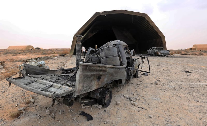 Destroyed vehicles are seen outside a hangar at Al-Watiya airbase, which was seized by forces loyal to Libya's UN-recognised Government of National Accord (GNA), southwest of the capital Tripoli, on May 18, 2020. Libya's UN-recognised government scored another battlefield victory Monday against strongman Khalifa Haftar, capturing the key rear base used by his fighters in a conflict now in its second year. Haftar, who controls swathes of eastern Libya, launched an offensive in April last year against the capital Tripoli, seat of the UN-recognised Government of National Accord (GNA). / AFP / Mahmud TURKIA
