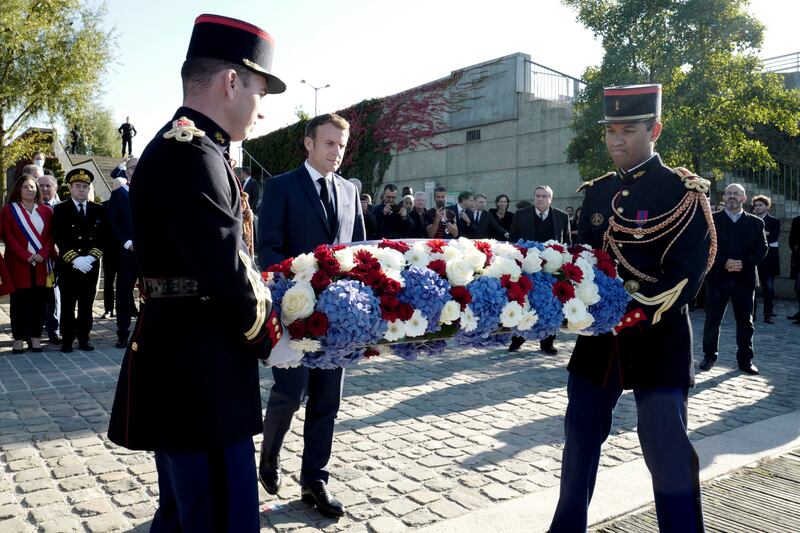 French President Emmanuel Macron lays a wreath near Pont de Bezons during a ceremony to mark the 60th anniversary of the Paris massacre. Reuters