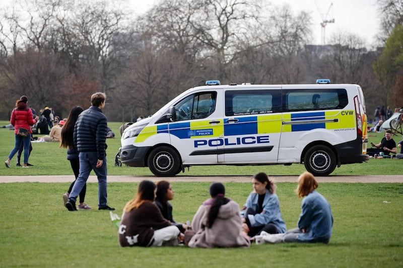 A police van patrols as people relax in Hyde Park. AFP