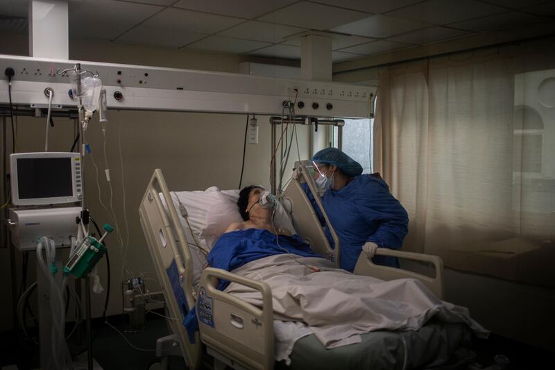 A Lebanese woman takes care of her mother with COVID-19 inside the Intensive Care Unit of Rafik Hariri University Hospital. Getty Images