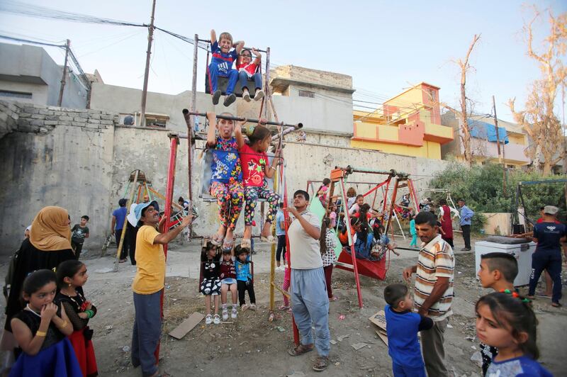 Iraqi children play on a swing in Mosul, Iraq. Reuters