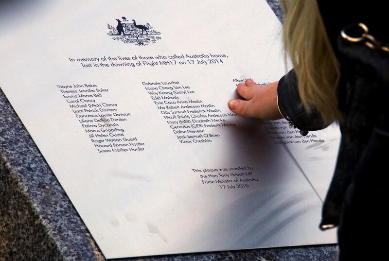 FILE PHOTO - A relative of an Australian victim of Malaysia Airlines jet MH17 touches a memorial that was unveiled outside Parliament House in Canberra, Australia, July 17, 2015.   REUTERS/David Gray/File photo