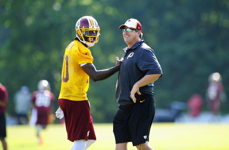 Washington Redskins quarterback Robert Griffin III, left, is all smiles with new coach Jay Gruden. Nick Wass / AP Photo

