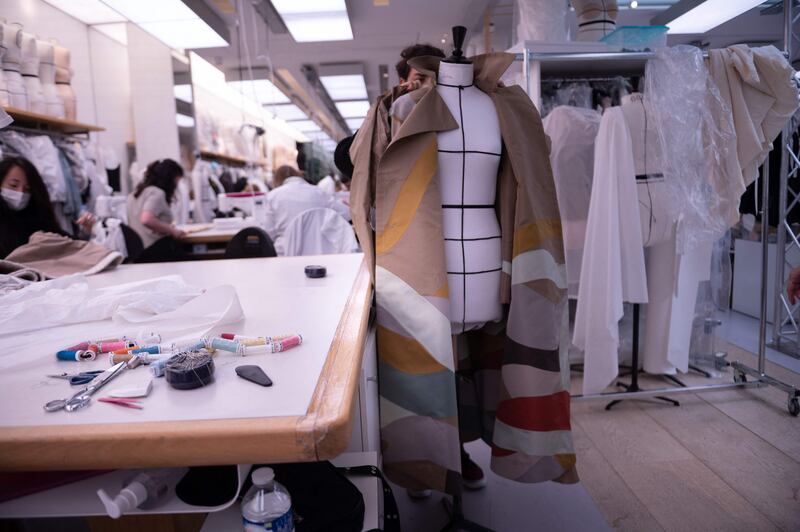 An employee works on the haute couture collection at the Christian Dior headquarters in Paris on July 3, 2021.