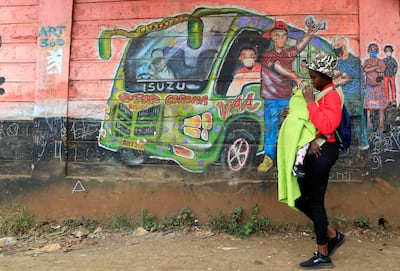 A woman walks past a wall mural in the Kibera settlement in Nairobi. Reuters