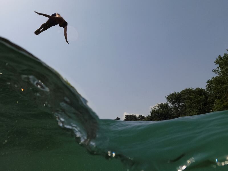 A swimmer dives into the Drinos river to cool off during the heat wave, near the city of Tepelena, southern Albania. Reuters