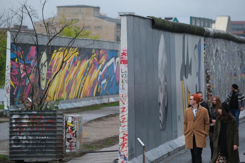 Visitors walk along a still-standing section of the former Berlin Wall called the East Side Gallery in Berlin, Germany. Getty Images