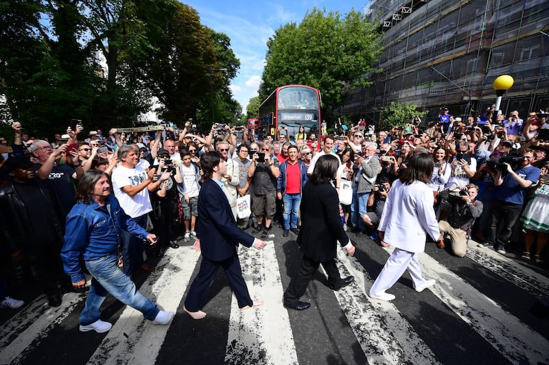 ***BESTPIX*** LONDON, ENGLAND - AUGUST 08: Beatles impersonators recreate the iconic 'Abbey Road' photograph made 50 years ago today, on August 8, 2019 in London, England. 50 years ago today, John Lennon, Paul McCartney, George Harrison and Ringo Starr held up traffic on the zebra crossing outside their recording studio in north London to get the cover shot for the album, Abbey Road. (Photo by Leon Neal/Getty Images)