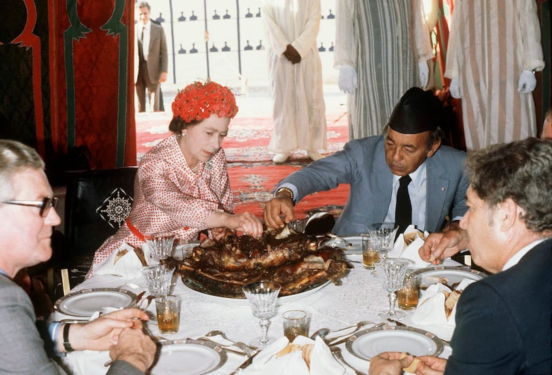 Queen Elizabeth eats with her hands in the desert with King Hassan during her visit to Morocco on October 27, 1980. Getty