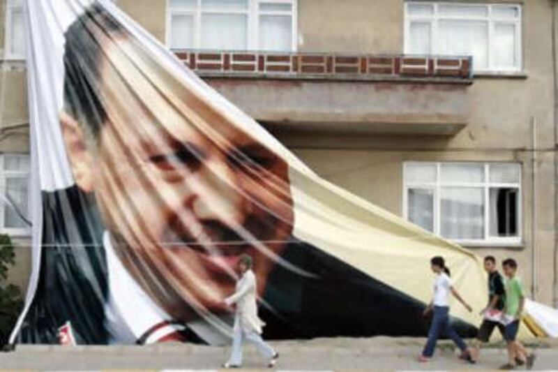 People walk in front of a giant poster of the Turkish prime minister Recep Tayyip Erdogan, in Sakarya, Turkey.