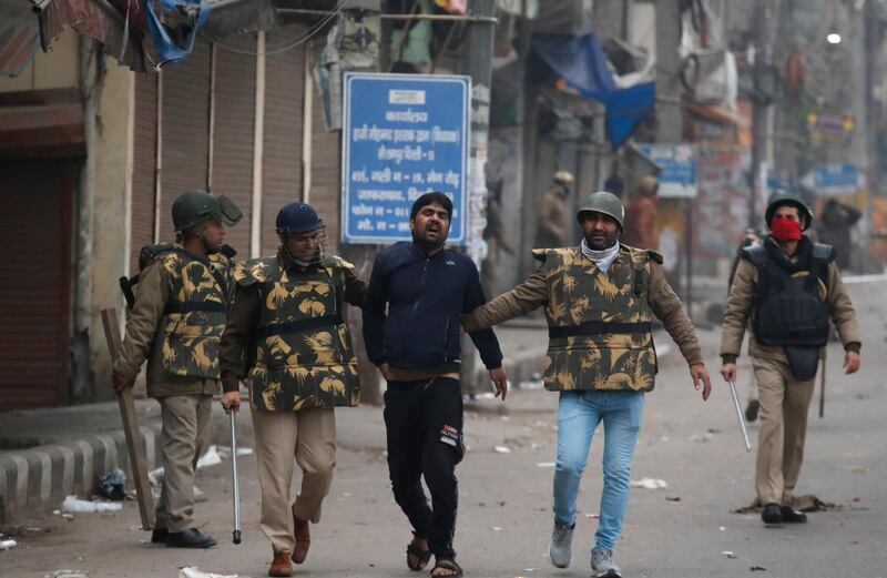 Policemen detain a protester in the Seelampur area of New Delhi. AP Photo