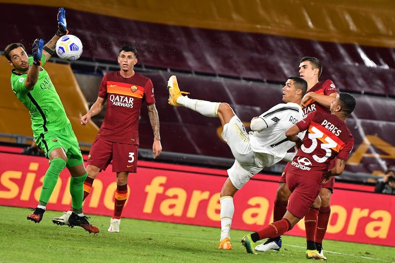 Juventus' Portuguese forward Cristiano Ronaldo (3rdR) eyes the ball as he scores an equalizer past Roma's Italian goalkeeper Antonio Mirante (L) during the Italian Serie A football match Roma vs Juventus on September 27, 2020 at the Olympic stadium in Rome. (Photo by Tiziana FABI / AFP)