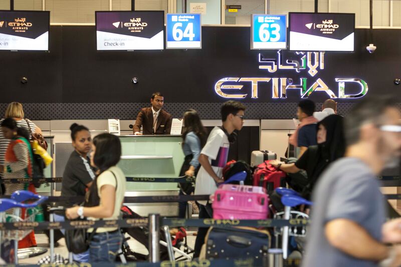 Passengers checking in for flights at the Abu Dhabi International Airport. Antonie Robertson / The National