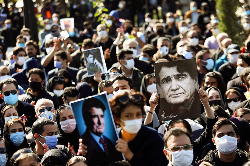 Fans raise portraits of Mohammad Reza Shajarian during his funeral. AFP