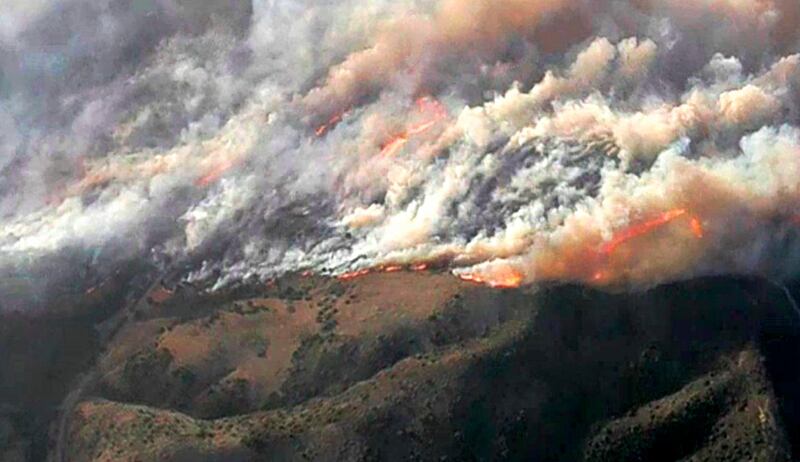 Smoke and flames from the Silverado fire threatens areas near Irvine, California, on Monday, October 26, 2020. KNBC-TV via AP