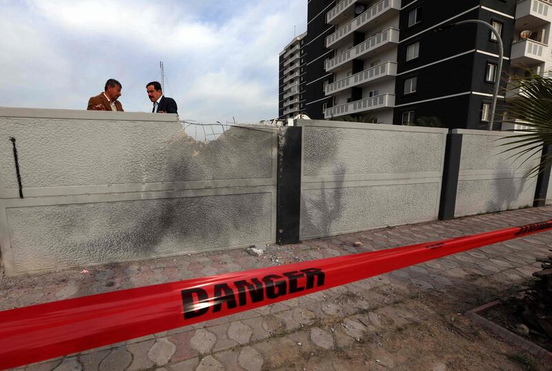 Two men stand near the scene of a rocket attack targeting Erbil's airport, the first time in nearly two months that Western military or diplomatic installations have been targeted in Iraq. AFP