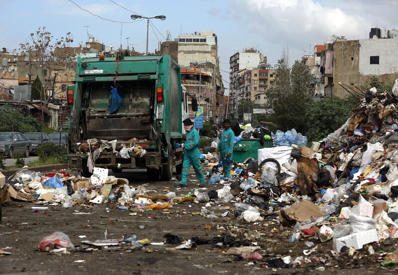 Asian employees from Sukleen, a local trash management company, collect garbage from a temporary garbage dump in an eastern suburb of the Lebanese capital, Beirut, on March 4, 2016. (Photo by PATRICK BAZ / AFP)