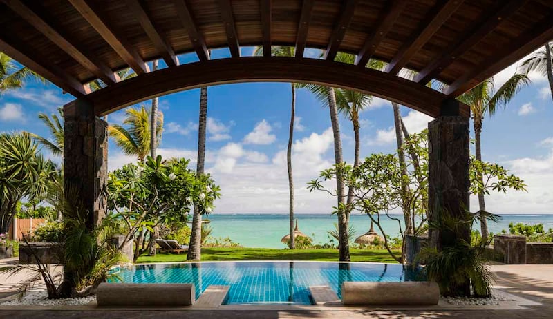 An infinity pool, palm trees and Indian Ocean views at One&Only Le Saint Geran, Mauritius. 