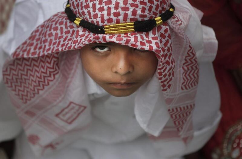 A Nepalese Muslim boy reacts to the camera as he waits to offer prayers on Eid Al Fitr at a mosque in Kathmandu, Nepal, Saturday, July 18, 2015. Millions of Muslims across the world are celebrating the Eid Al Fitr holiday, which marks the end of the month-long fast of Ramadan. Niranjan Shrestha / AP photo