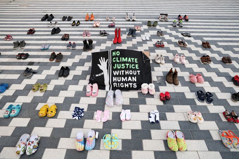 Protesters held flags reading: 'No climate justice without human rights.' Chris Whiteoak / The National