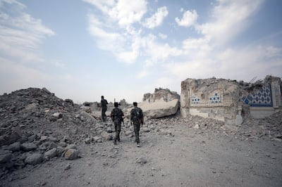 Fighters from Syrian Democratic Forces (SDF) stand near destroyed Uwais al-Qarni shrine in Raqqa, Syria September 16, 2017. REUTERS/Rodi Said