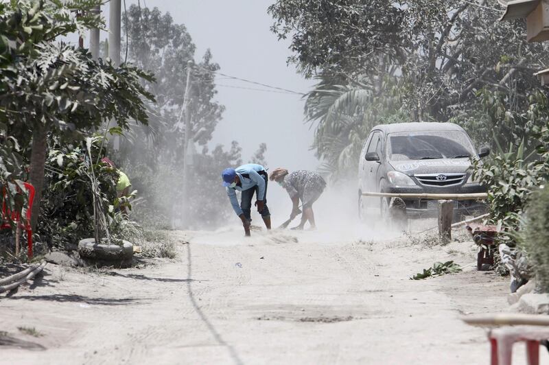 Men clean volcanic ash from the street after Mount Sinabung volcano spewed thick volcanic ash across the area the day before in Karo, North Sumatra. Kadri Boy Tarigan / AFP