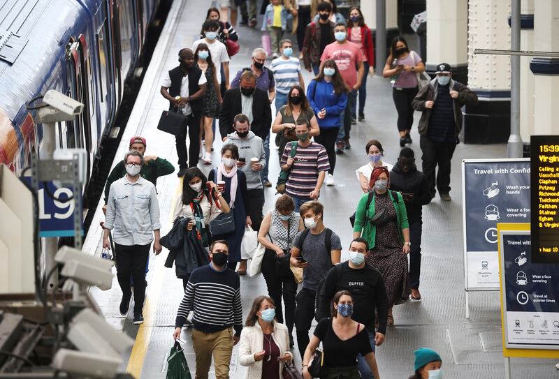 People, some wearing protective face masks, walk through Waterloo Station in London. Prime Minister Boris Johnson is set to announce a plan to remove remaining Covid-19 restrictions on July 19.