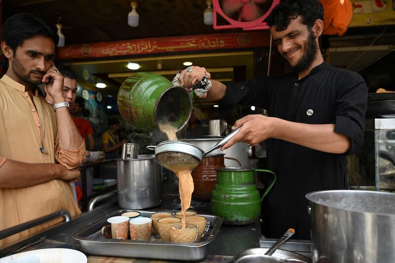 An employee pours tea for customers at a restaurant in Islamabad. AFP