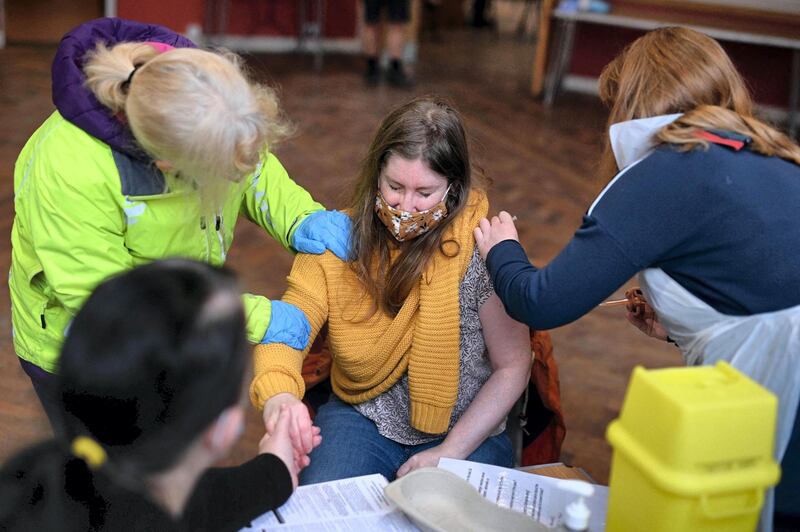 Doctor Lucie Brittain (R) administers an injection of AstraZeneca/Oxford Covid-19 vaccine to a patient at the vaccination centre set up at St Columba's church in Sheffield, northern England, on February 20, 2021.   / AFP / Oli SCARFF
