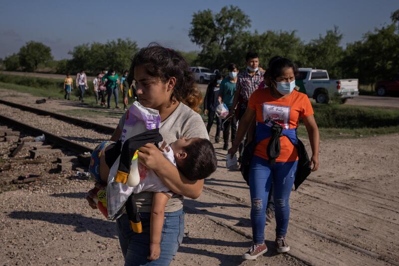 Sherry, 17, holds her one-year-old son Ian as she leads a line of unaccompanied minors who were being prepared for transport with other asylum-seeking migrants from Central America after they crossed the Rio Grande river into the United States from Mexico, in La Joya, Texas, U.S., May 7, 2021.  REUTERS/Adrees Latif